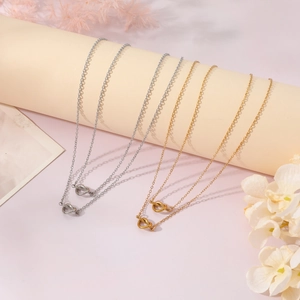 Detail of silver and gold knot pendant necklaces on display with soft lighting