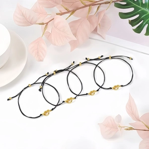 Set of four adjustable black woven bracelets with golden heart knots and round beads
