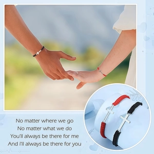 Close-up of woven couple bracelets with silver cross pendants on male and female wrists