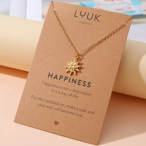 Detail der goldenen Sonnen-Halskette auf eleganter Geschenkkarte zur Präsentation
