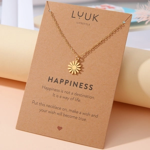 Goldene Gänseblümchen-Halskette auf Kraftpapier-Geschenkkarte mit Zitat