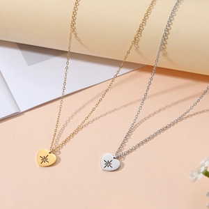 Detailansicht der herzförmigen Gold- und Silberketten mit gravierten Sterndetails