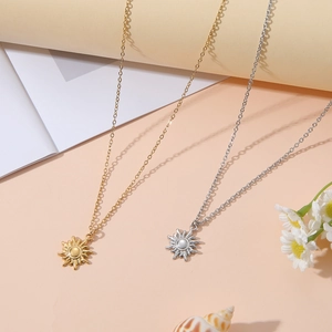 Nahaufnahme von Gold und Silber Sonnenanhänger Halsketten mit zierlichen Ketten auf Sommer-Deko