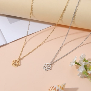 Detail von gold- und silbernen Pfotenanhängern mit Herzmotiven an feinen Ketten
