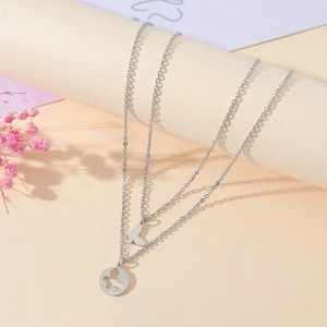 Détail d'un collier double épaisseur en acier inoxydable avec pendentifs papillons