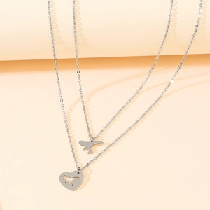 Détail du collier dinosaure argenté avec chaînes superposées et pendentif cœur creux