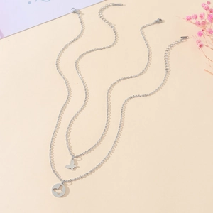Gros plan d'un collier double rang en acier inoxydable avec pendentifs papillon et fermoir