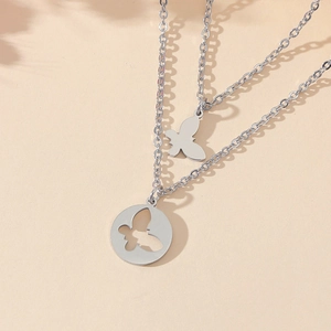 Gros plan sur un collier double rang argenté avec pendentifs papillon variés