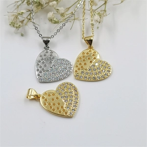 Detailed view of heart pendants with honeycomb texture and pavé zircon stones in gold and silver