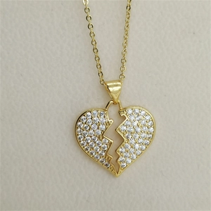 Golden broken heart pendant necklace with shimmering zircons on elegant chain