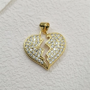 Macro detail of broken heart pendant with pavé-set zircons and gold-plated finish