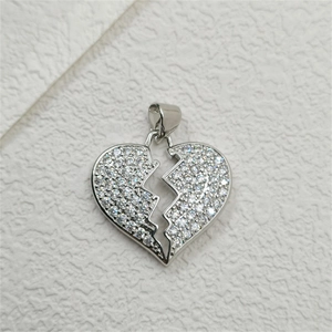 Macro shot of silver broken heart pendant with micro-paved sparkling zircon stones