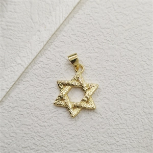 Macro detail of gold-plated Star of David pendant with textured relief finish