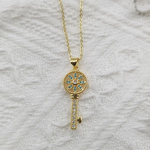 Exquisite goldene Schlüsselkette mit blauem Edelstein und Zirkon auf weißer Spitze