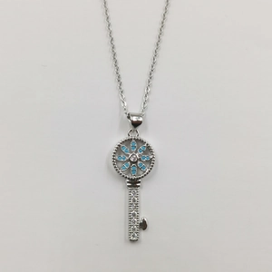 Makro-Detail der silbernen Schlüsselkette mit blauer Zirkonblume und Pavé-Strasssteinen