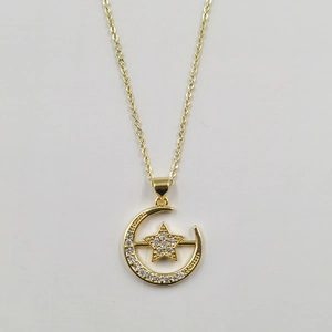 Detailed close-up of a gold moon and star pendant necklace with sparkling zircon stones