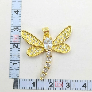 Detailed size measurement of a gold dragonfly pendant featuring white cubic zirconia stones