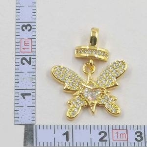 Macro shot of gold bow pendant with white cubic zirconia and square center stone