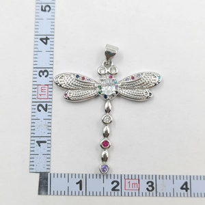 Detail view of a dragonfly pendant with zircon inlay and ruler showing 4.5cm size