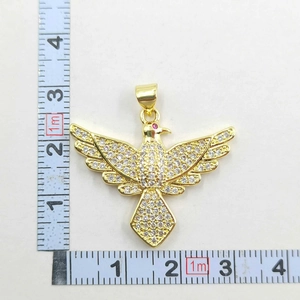 Detailed view of a gold-plated flying bird pendant with white zircons and red gem eye