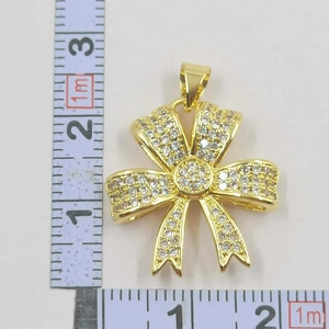 Macro shot of 25mm bow necklace pendant with sparkling zircons and a gold plating finish