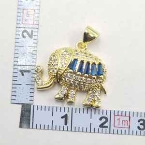 Detail of gold elephant pendant featuring white zircons and blue square stones