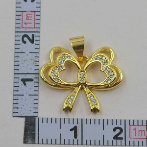 Detailed size measurement of gold bow pendant with zircon stones showing 2.5cm dimensions