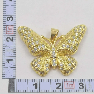 Detailed measurement of gold butterfly pendant with white zircons showing 32mm width