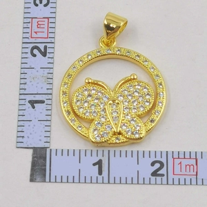 Detailed view of a gold-plated butterfly pendant with sparkling zircons and scale markings