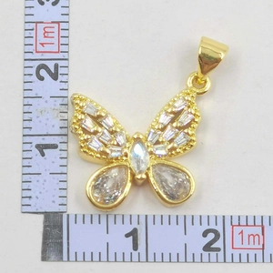 Detailed view of gold bow pendant measuring 20mm with sparkling zircon stones