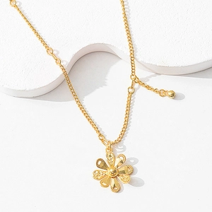 Macro shot of gold hollow flower pendant necklace showing detailed CNC floral craftsmanship