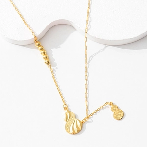 Detail of gold hollow gourd pendants with spiral textures and star patterns on a chain