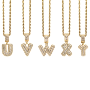 Detail of gold plated iced out letters U V W X Y pendants with shiny zirconia on rope chain