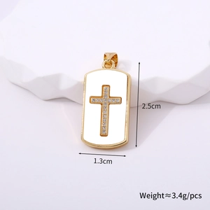 Detalle del colgante de cruz rectangular dorada con pedrería blanca de 2,5 cm por 1,3 cm