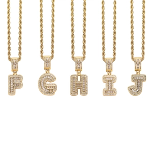 Close-up of iced out gold letters F to J with zircon stones on a rope chain