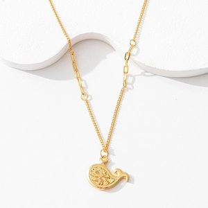 Detailed shot of golden whale pendant with hollow patterns and asymmetric chain