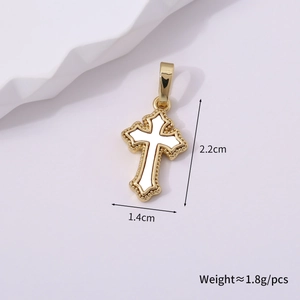 Close-up of a vintage golden cross pendant with white enamel inlay and beaded edges