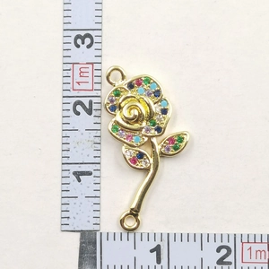 Macro detail of a rose flower pendant with colorful crystals and measurement scale