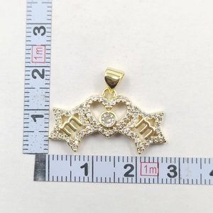 Detail shot of a golden heart MAMA pendant with zircons and measurements for scale
