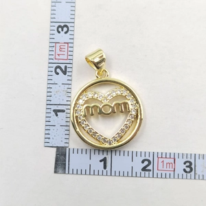 Detail of a gold heart-shaped pendant with 'MOM' lettering and shimmering zircons