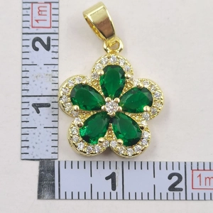 Macro view of sunflower clover flower pendant with green gems measuring 2cm in diameter
