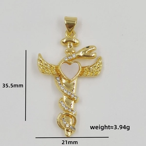 Macro detail of a golden snake dagger pendant with heart shell and crystal wings
