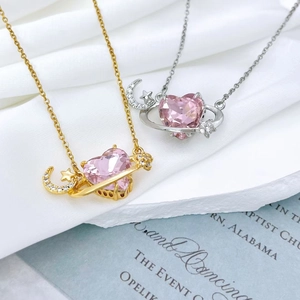Close-up of pink heart gemstone Saturn necklace with crescent moon and star elements