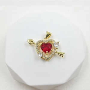 Detail of gold heart pendant with red zircon and sparkling cubic zirconia arrow design