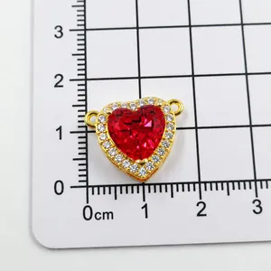 Macro shot of red heart pendant with white zircon pavé setting and gold base