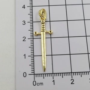 Detailed measurement of golden sword pendant showing 3.3cm length on scale