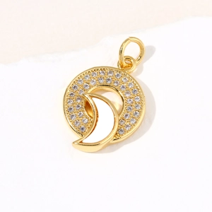 Detail of a gold-plated circular pendant featuring a shell crescent and micro-set cubic zirconia