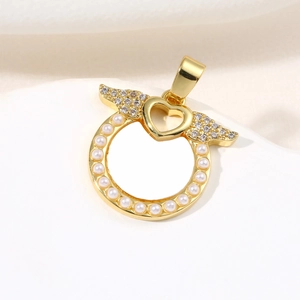 Golden round shell pendant with angel wings and pearls shown on a white stone surface