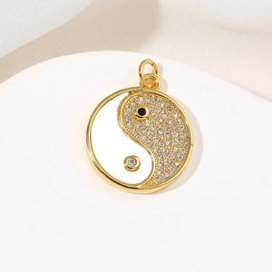 Golden Tai Chi Yin Yang pendant with white enamel and pavé cubic zirconia accents