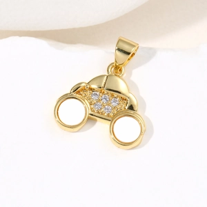 Pendentif voiture doré avec zircons incrustés sur une surface en marbre blanc